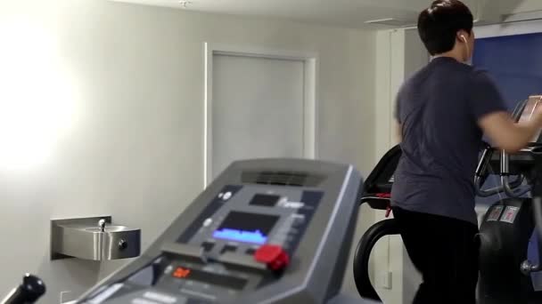 Tillbaka skott av man köra på ett löpband i en gym, fokus på människor — Stockvideo