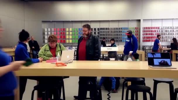 Motie van mensen surfen op nieuwe iphone binnen Apple store — Stockvideo