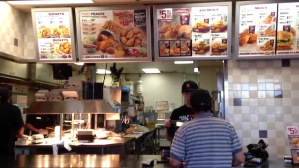 Trabajador preparando comida para el cliente dentro de la tienda KFC — Vídeos de Stock