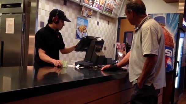 Persone che ordinano cibo e pagano in contanti al banco del check out KFC — Video Stock
