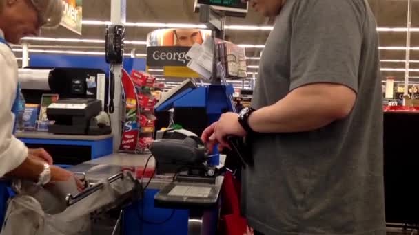 Pessoas que pagam alimentos no balcão de check-out dentro da loja Walmart — Vídeo de Stock