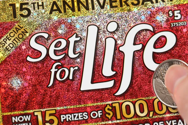 Close up woman scratching lottery ticket called set for life — Stock Photo, Image