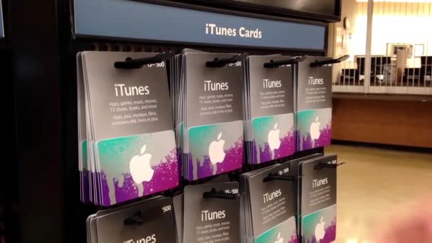 Muž výdeje dvou itunes dárkové karty uvnitř supermarketu — Stock video