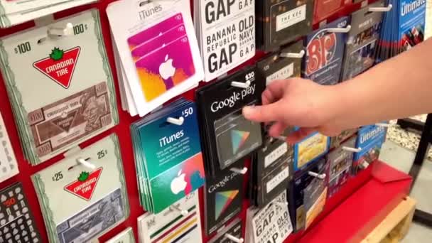 Homem escolhendo trinta dólares do Google Play cartão de presente dentro do supermercado — Vídeo de Stock