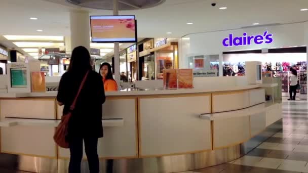 Mujer preguntando dirección de la tienda en el centro de información al cliente — Vídeo de stock