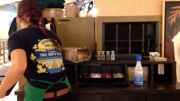 Pracownik Starbucks czyszczenia tabeli warsztat wewnątrz centrum handlowego. — Wideo stockowe