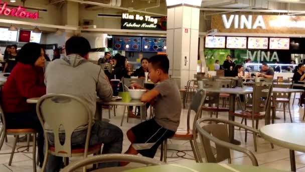 Gente disfrutando de un descanso de medio día en la cafetería moderna del patio de comidas . — Vídeo de stock