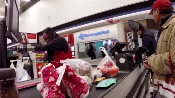 Close up of people paying foods at check out counter inside Superstore. — Stock Video