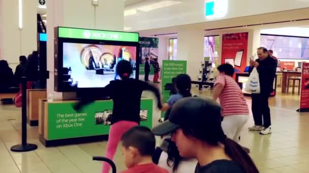 Staf Microsoft berdemonstrasi dengan permainan tari anak-anak di mal Burnaby — Stok Video