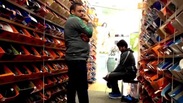 Gente buscando zapatos en una tienda de zapatos en el centro comercial Burnaby — Vídeos de Stock