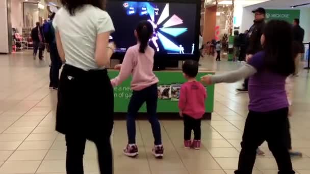 Personal de Microsoft demuestra con los niños juego de baile en el centro comercial en Burnaby — Vídeos de Stock