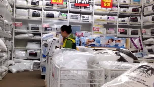 Woman choosing pillow inside Homesense store for closing sale. — Stock Video