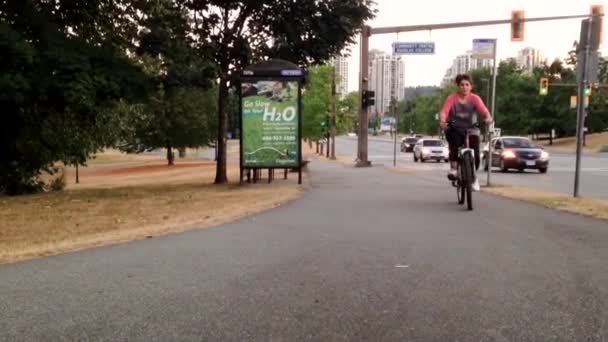 People riding bicycle beside bus station — Stock Video