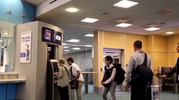 Menschen stehen Schlange, um am Flughafen Geld abzuheben — Stockvideo