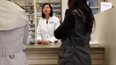 Resepsiyonist eczane mağaza içinde sorular soran insanlar