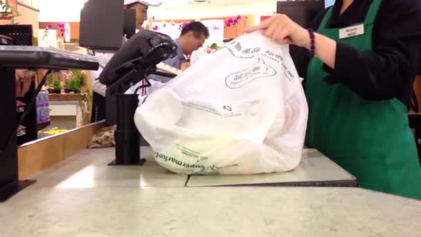 Customer paying for groceries at checkout counter inside T&T supermarket — Stock Video