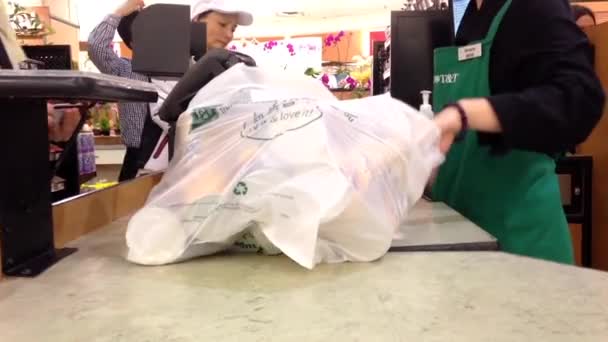 Customer paying for groceries at checkout counter inside T&T supermarket — Stock Video