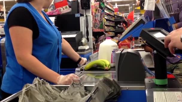 Hombre pagando alimentos con tarjeta de crédito en el mostrador de pago de Walmart — Vídeos de Stock