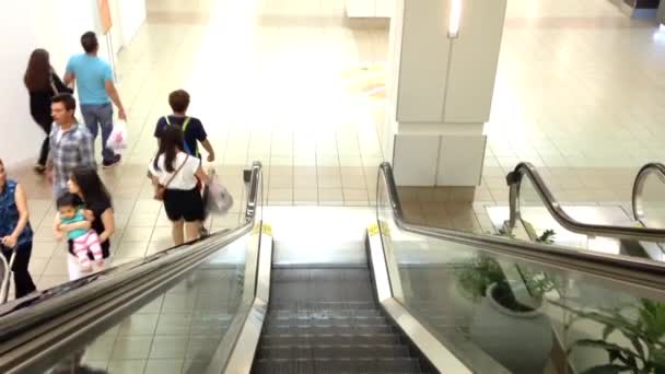 La gente sube por la escalera mecánica en el centro comercial — Vídeo de stock