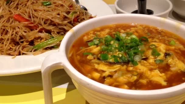 Essen chinesischer gebratener Nudeln und Suppe im Restaurant — Stockvideo