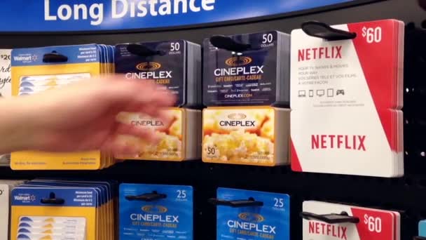 Kvinnan plockning femtio dollar cineplex presentkort inuti stormarknad — Stockvideo