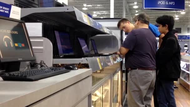 La gente que intenta la computadora de la manzana dentro mejor tienda de compra — Vídeo de stock