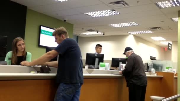 Människor vid service disken pratar med teller inuti Td Bank. — Stockvideo