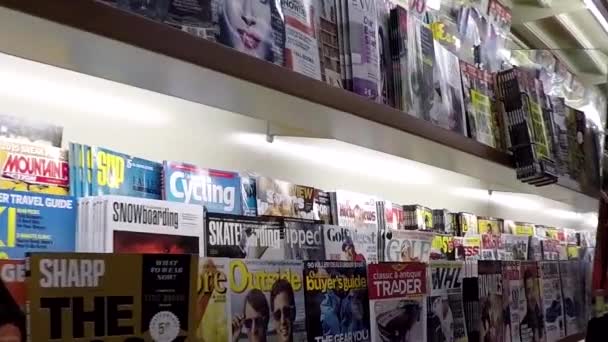 Close up hand choosing magazine at London drugs store — Stock Video