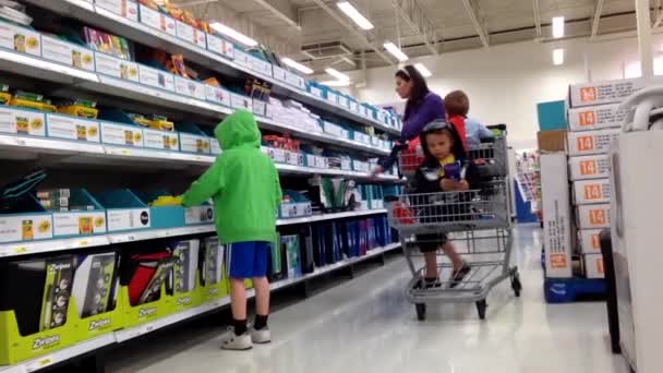 Mãe comprando alguns materiais de escritório para seus filhos de volta às coisas da escola dentro da superloja . — Vídeo de Stock