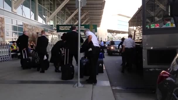 Pilote et hôtesse de l'air descendant de la navette à l'entrée d'arrivée internationale — Video