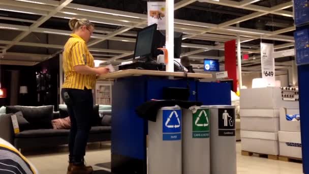 Trabajadora en la estación de información revisando algunos datos dentro de la tienda Ikea . — Vídeos de Stock