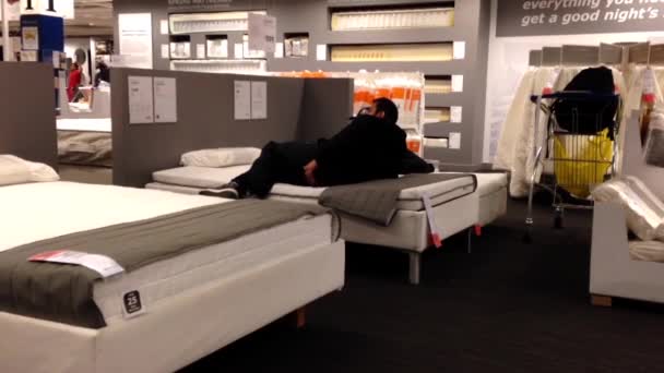 Client essayant un nouveau matelas à l'intérieur du magasin Ikea à Coquitlam BC Canada . — Video