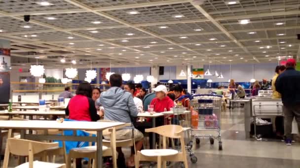 Gente disfrutando la comida en la cafetería del patio de comidas dentro de la tienda Ikea . — Vídeos de Stock