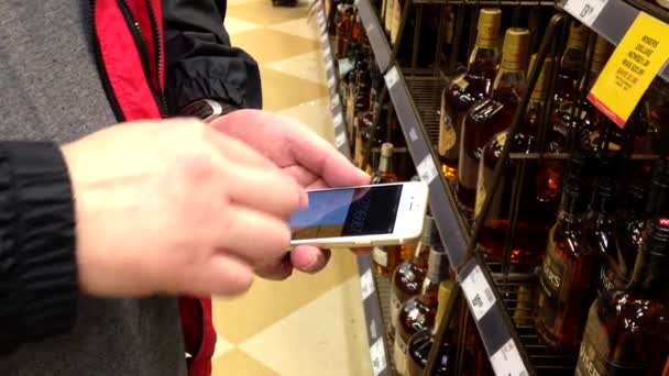 Homem que conta o preço do vinho dentro da loja de bebidas BC . — Vídeo de Stock