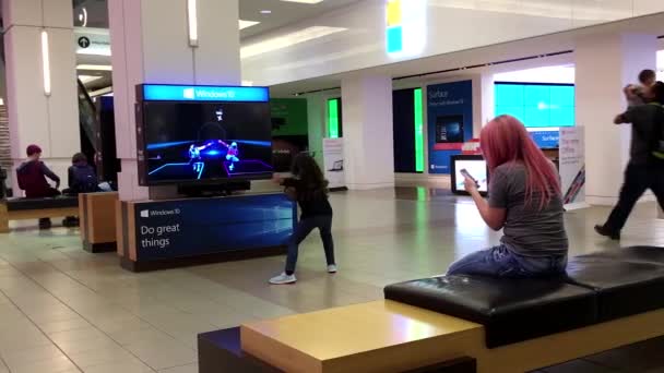 Barn dans med Microsoft visade spelet bredvid fönstret butik — Stockvideo