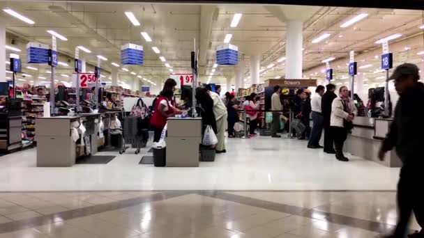 Close up of people paying foods at check out counter inside Superstore. — Stock Video