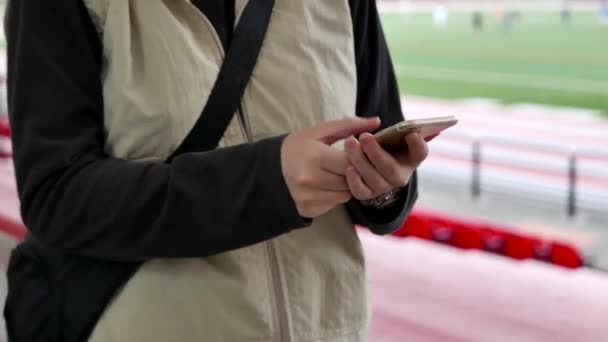 Kobieta czytająca telefonu komórkowego wiadomość w sport złożony — Wideo stockowe