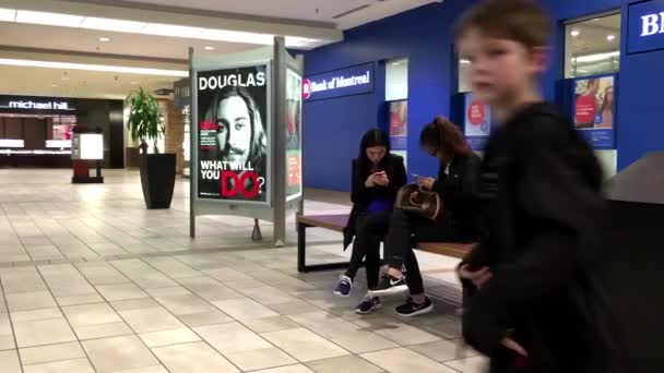 Feche as pessoas sentadas na área de descanso e usando o novo iphone 6s dentro do shopping — Vídeo de Stock