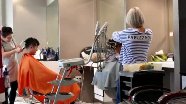 Güzellik salonunda bir saç kesimi olan insanlar