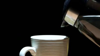 Bir fincan kahve siyah bir zemin üzerine dökerek sıcak suya