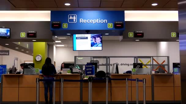 People line up for applying driver license at reception site inside ICBC — Stock Video