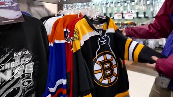 Woman picking one of Boston Bruins Premier Jersey cloth — Stock Video