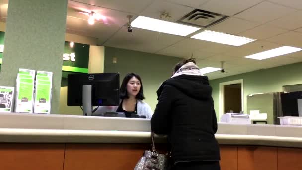 Les gens au comptoir de service parlent au caissier de la Banque TD — Video