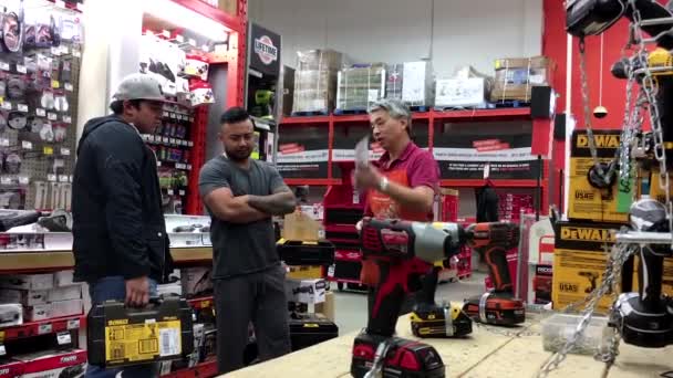 Personas haciendo preguntas a los trabajadores sobre la compra de taladro eléctrico en la tienda Home Depot — Vídeos de Stock
