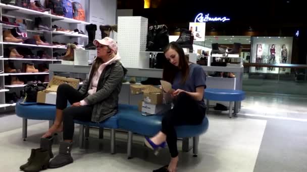 Mujer probando zapatos nuevos dentro de la tienda de zapatos de primavera — Vídeo de stock