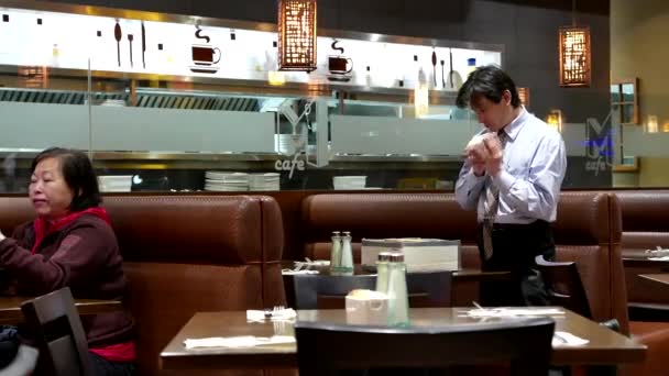 Waiter cleaning table and putting sugar bags in order inside Chinese restaurant — Stock Video