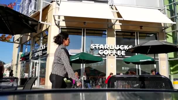 Un lado de la gente que bebe café Starbucks en un día soleado — Vídeos de Stock