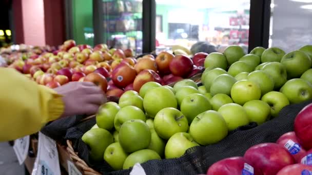 Kvinnan att välja grönt äpple i mataffären producera Institutionen — Stockvideo