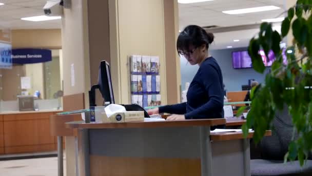 Ena sidan av receptionist arbetar av kunddata inuti Royal bank — Stockvideo