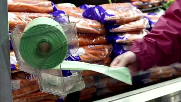 Frau nimmt Plastiktüte für Lebensmittel im Lebensmittelgeschäft — Stockvideo